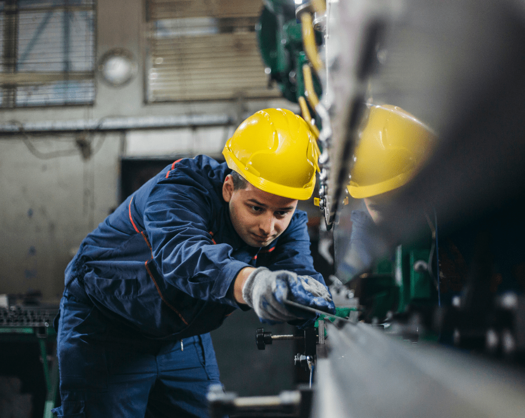 Metal worker operating a sheet press machine