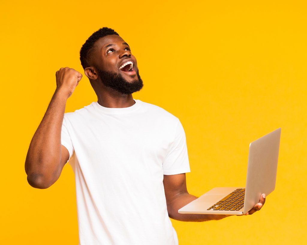 guy celebrating with laptop in his hand