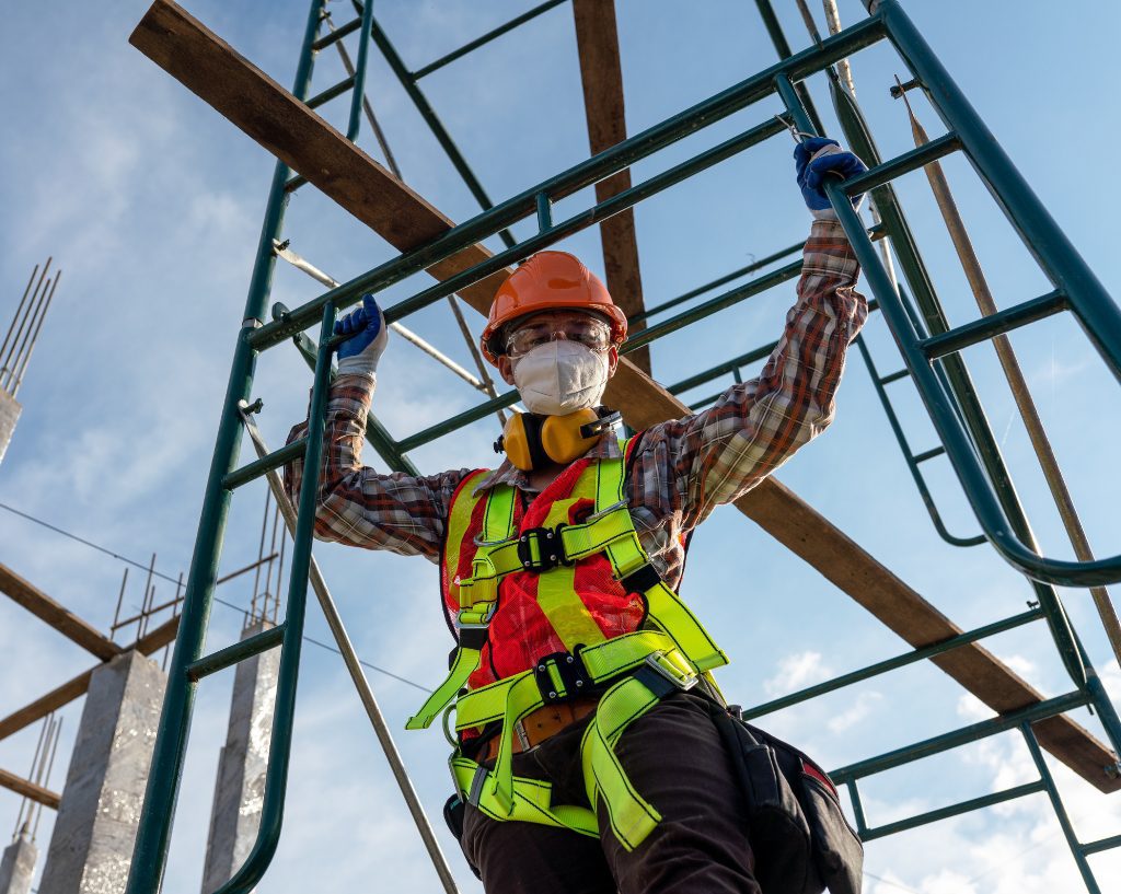 Worker in safety harness on metal structure